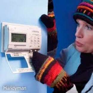 Cold woman near thermostat