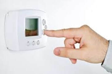 man setting thermostat